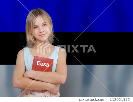 Cheerful smiling teen girl embracing book with inscription Estonian in Estonian language on flag Cheerful smiling teen girl embracing book with inscription Estonian in Estonian language on flag 112051525