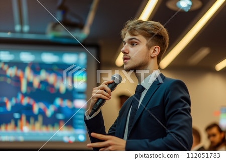 Young entrepreneur explaining concepts against a backdrop of glowing stock market screens 112051783