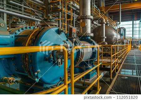 Industrial machinery with an array of steel pipes, cables, and valves in a manufacturing setting 112051820