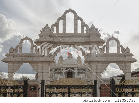 Entrance archway of the Neasden temple (BAPS Shri Swaminarayan Mandir) against a nice cloud sky background. 112053755