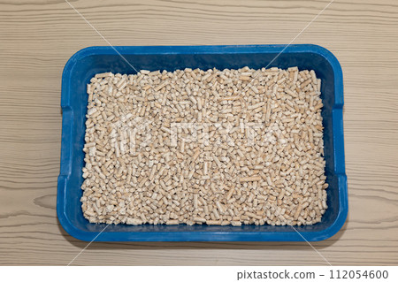 Clean cat litter box with fresh filler on a wooden floor 112054600