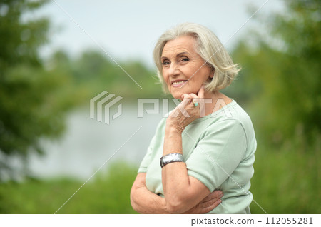 Portrait of happy senior woman posing at forest 112055281