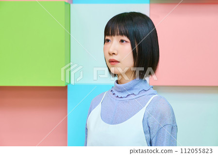 色彩繽紛的背景，一位面容嚴肅的年輕女子 112055823