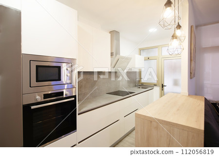 modern kitchen in a home equipped with appliances and decoration 112056819