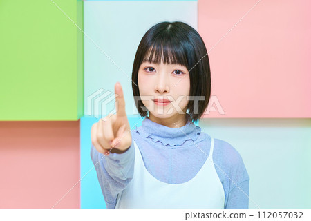 Colorful background with young woman in pointing pose Colorful background with young woman in pointing pose 112057032