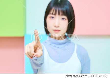 色彩繽紛的背景與年輕女子的指點姿勢 112057033