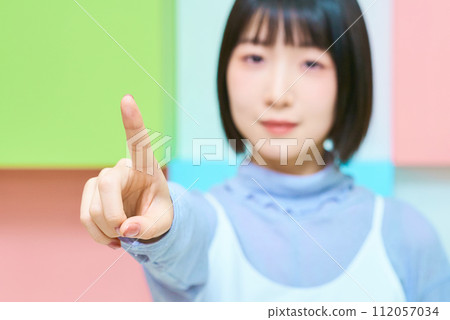 Colorful background with young woman in pointing pose Colorful background with young woman in pointing pose 112057034