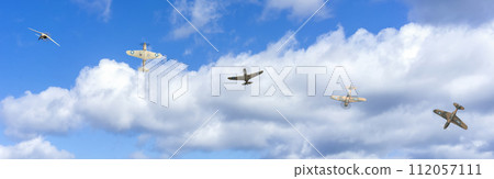 Vintage Aircraft Squadron Soaring Through Blue Skies Amongst Fluffy Clouds 112057111
