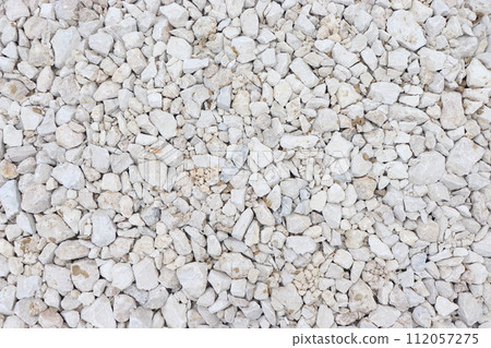white stones on the ground, background with white small horses 112057275