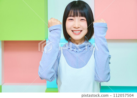 Colorful background with young woman doing fist pump 112057504