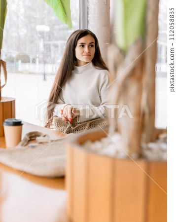 Young attractive woman sitting in coffee shop cafe Young attractive woman sitting in coffee shop cafe 112058835