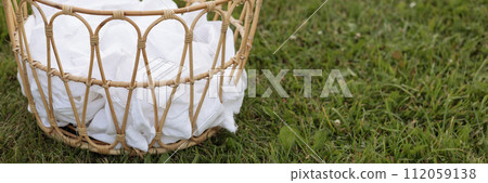 Banner wicker storage basket with white sheets on grass field 112059138