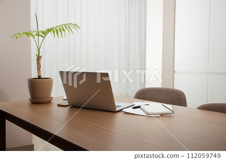 Laptop and flower pot on wooden table at home interior Laptop and flower pot on wooden table at home interior 112059749