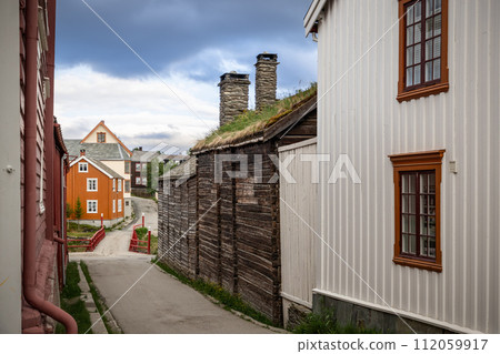 Roros, the street view showcases timber walls, sod roofs, and colorful traditional Norwegian houses Roros, the street view showcases timber walls, sod roofs, and colorful traditional Norwegian houses 112059917