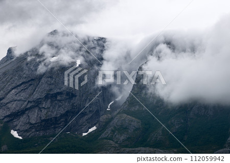 Norwegian highlands spectacle with ghostly clouds flowing like a river over steep ancient cliffs 112059942