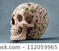 A human skull painted with beautiful flowers on a gray background. Close-up. Generated by AI 112059965