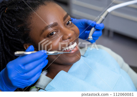 Multicultural lady in dental clinic doing teeth checkup 112060081