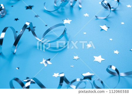 Festive blue background with silver serpentine and confetti stars, boy or newborn birthday concept. High quality photo Festive blue background with silver serpentine and confetti stars, boy or newborn birthday concept. High quality photo 112060388