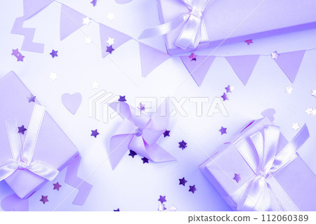 Purple background with pink ornaments and gift boxes, decorative, delicate, background. concept of a party or birthday party in violet colors or a newborn baby girl. High quality 4k footage. 112060389