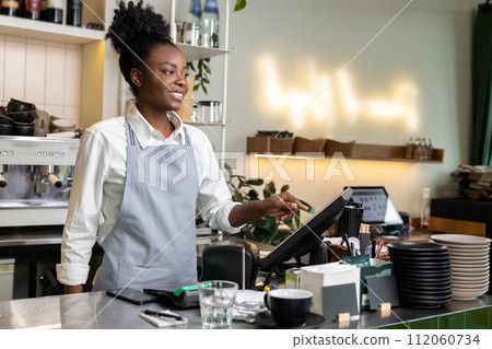 Woman waitress barista bartender checking bill before printing it on digital cash register Woman waitress barista bartender checking bill before printing it on digital cash register 112060734