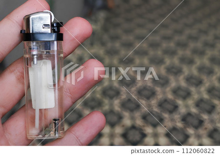 Hand Holding a Transparent Gas Lighter 112060822