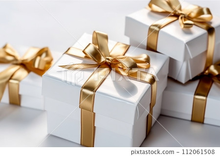 gift boxes with golden ribbons on a pale background 112061508