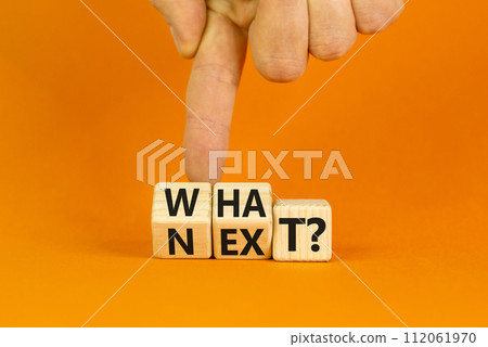 What next symbol. Concept words What next on wooden blocks. Changed words what to next. Beautiful orange table orange background. Businessman hand. Business What next concept. Copy space. 112061970