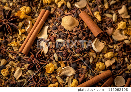 Assorted spices with cinnamon sticks, star anise, and cloves on a textured background 112062108