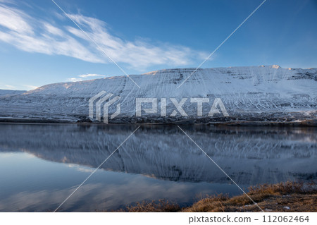 Reflection of a mountain in the fjord, Iceland 112062464