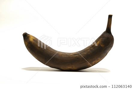 A rotten banana. A black old banana on a white background. 112063140