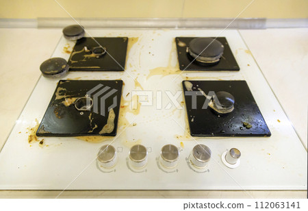 Dirty gas hob in the kitchen. The concept of removing grease stains. Dirty gas hob in the kitchen. The concept of removing grease stains. 112063141