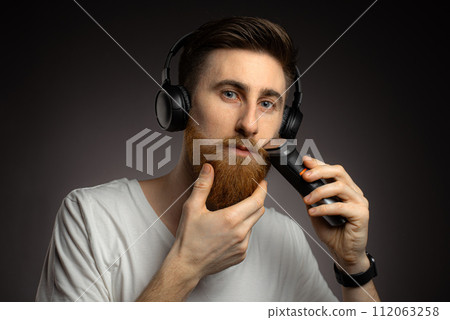 man in headphones with hair trimmer man in headphones with hair trimmer 112063258