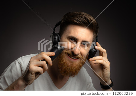 man in headphones with hair trimmer man in headphones with hair trimmer 112063259