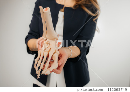 Doctor explaining operation to foot on bone model Doctor explaining operation to foot on bone model 112063749