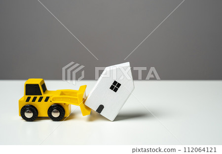 A bulldozer demolishes a house. Toy figures. Territory clearing service. The bulldozer intends to demolish the house. Making way for future developments. A bulldozer demolishes a house. Toy figures. Territory clearing service. The bulldozer intends to demolish the house. Making way for future developments. 112064121