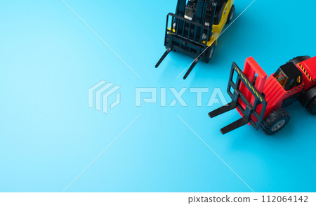 Forklifts and space for text on a blue background. Efficient logistics and distribution systems. Management of warehousing and shipping of orders and goods. Forklifts and space for text on a blue background. Efficient logistics and distribution systems. Management of warehousing and shipping of orders and goods. 112064142