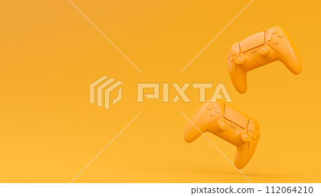 Video game joysticks or gamepads in plain monochrome yellow color background 112064210