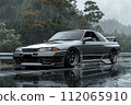 A sleek silver car with shiny alloy wheels parked on a gray surface 112065910
