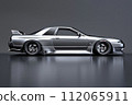 A sleek silver car with shiny alloy wheels parked on a gray surface 112065911