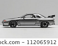 A sleek silver car with shiny alloy wheels parked on a gray surface 112065912