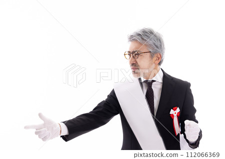 Gray-haired election candidate giving a speech on the street 112066369