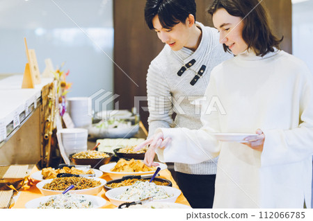 夫婦在自助餐廳選擇食物 112066785