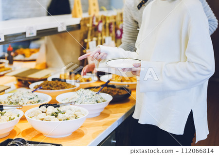 Couple choosing food at a buffet style restaurant 112066814