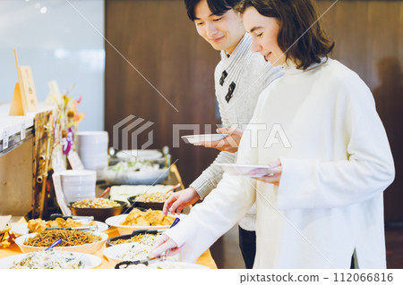 Couple choosing food at a buffet style restaurant 112066816