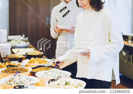 Couple choosing food at a buffet style restaurant 112066820