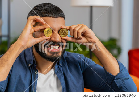 Indian freelancer man stock trader holding two golden bitcoins BTC successful developer programmer Indian freelancer man stock trader holding two golden bitcoins BTC successful developer programmer 112066940