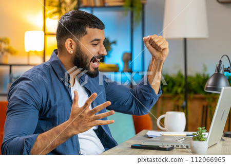 Happy amazed Indian man working on laptop celebrate game winning thumbs up good career business news Happy amazed Indian man working on laptop celebrate game winning thumbs up good career business news 112066965