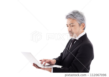 Gray haired man using a laptop Gray haired man using a laptop 112067096