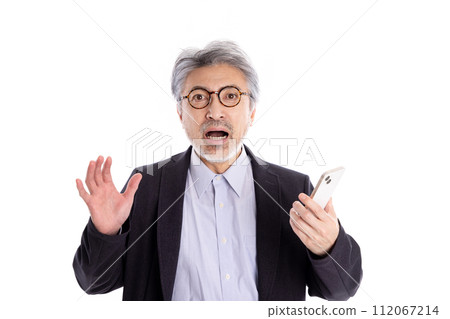 灰髮男子看著他的智慧型手機,看起來很驚訝 灰髮男子看著他的智慧型手機,看起來很驚訝 112067214