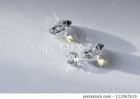 brilliant cut diamond held by tweezers on white background 112067610